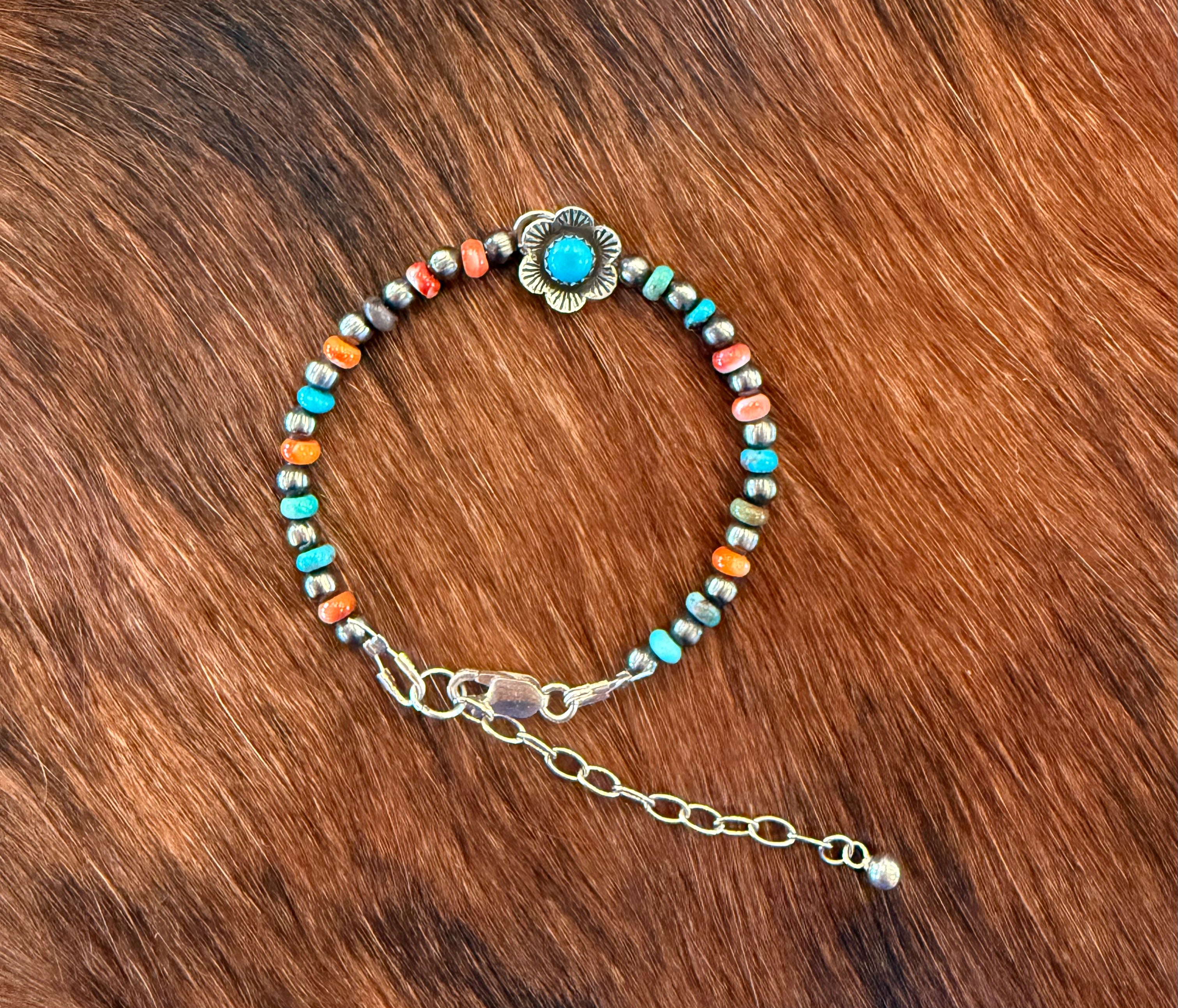 Navajo pearl, turquoise, and red spiny bracelet with silver flower
